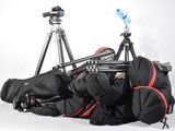 a lot of bags and a tripod sitting on the ground