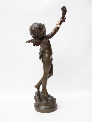 an antique bronze statue of a boy holding a bird on a white background