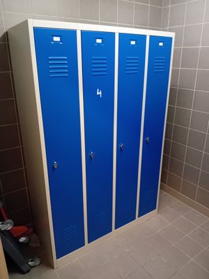 trois casiers bleus dans une salle de bains, à côté des toilettes