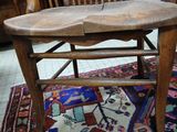 a wooden chair that is on a rug in a room