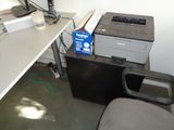 a printer sitting on top of a desk next to a chair