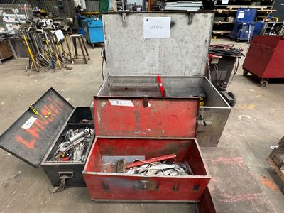 une boîte à outils rouge contenant des outils, dans un entrepôt
