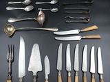 many different types of knives and spoons on the table