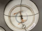 a white plate with a clock on it with a wire around it