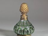 flacon de parfum en verre vert et doré, orné d'un ananas sur le bouchon