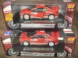 deux petites voitures rouges exposées dans une boîte