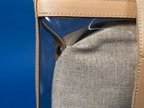 someone is holding a clear bag with a brown handle