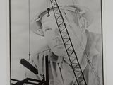 a black and white photo of a man with a construction crane