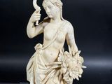 an antique carved ivory figurine of a woman holding a flower