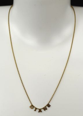 un collier en or orné de trois breloques autour du cou d'un mannequin