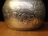 an old silver bowl sitting on top of a wooden box