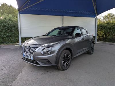 un SUV Nissan gris garé devant un garage
