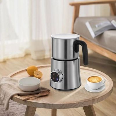 une photo d'une cafetière posée sur une table, à côté d'une tasse de café