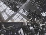 black and white photograph of a factory with workers working on machines