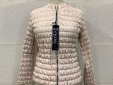 the jacket is on a mannequin stand in front of a brick wall