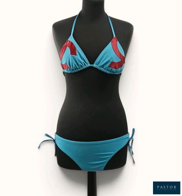 un gros plan sur un bikini posé sur un mannequin, avec un haut de bikini bleu et rouge