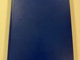 a blue book sitting on top of a table next to a white wall