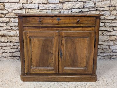 a wooden cabinet with two doors and a drawer underneath it