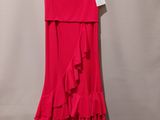 a red dress hanging on a hanger against a wall