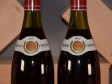 two bottles of wine sitting next to each other on a table