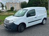 La camionnette est garée sur le bord de la route, devant un immeuble.