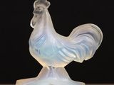 a glass figurine of a rooster on a table
