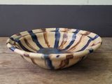 a small bowl on a wooden table with a wall in the background