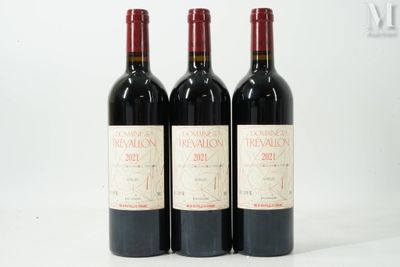 trois bouteilles de vin rouge sont alignées sur une surface blanche