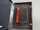 a black box with a red label and a pen in it