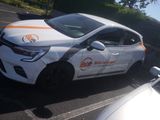 a white car with orange stripes parked on the side of the road