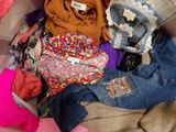 une pile de vêtements posée sur un lit