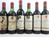 six bouteilles de vin sont alignées sur une table