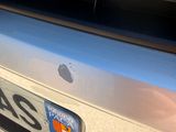 an apple logo on the back of a silver car