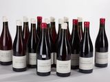 six bottles of wine are lined up in a row on a white surface