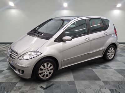 la photo d'une petite voiture argentée garée dans un garage