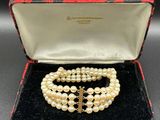 a close up of a necklace and bracelet in a box on a table