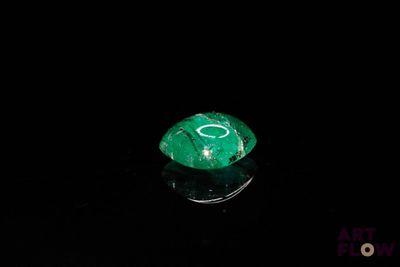 a close up of a green gemstone on a black surface