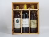 trois bouteilles de vin dans un coffret en bois sur une table