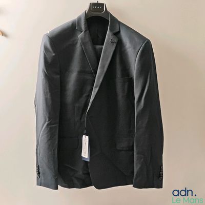 un costume suspendu à un cintre accroché au mur