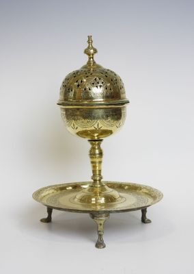 une assiette ancienne en laiton avec un couvercle et un socle, sur fond blanc