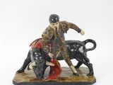 figurine représentant un homme chevauchant un taureau, avec un taureau devant lui