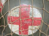 a helmet with a red cross painted on the side of it