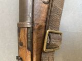 a brown leather bag with a pair of knives on it
