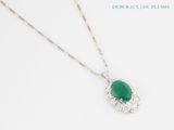 a close up of a necklace with a green stone on it