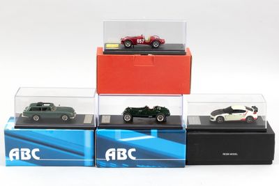 Quatre modèles réduits de voitures différents sont exposés dans une vitrine posée sur une surface blanche.