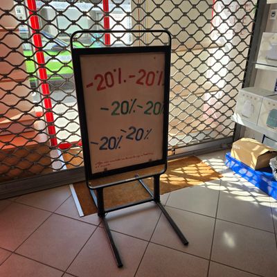 une pancarte placée devant une porte sur laquelle est apposée une étiquette de prix