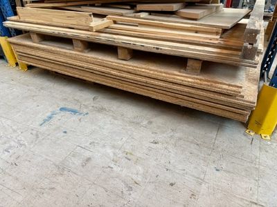 plusieurs pièces de bois sont empilées sur des palettes dans un entrepôt