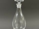 clear glass perfume bottle with a clear top on a gray surface