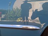 a reflection of a man on the side of a blue car