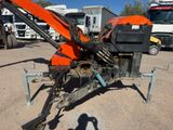 an orange machine that is sitting in the dirt